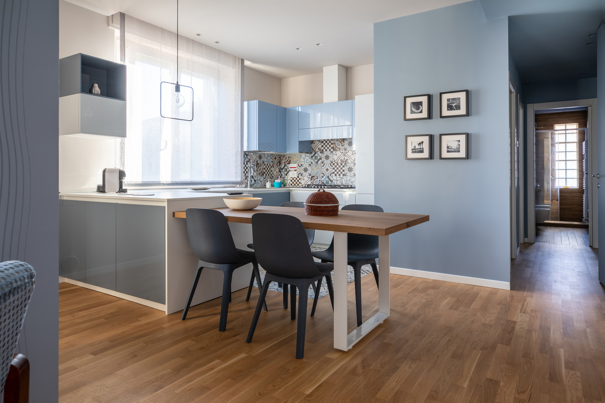 Interior of modern kitchen with wood floors and blue walls.